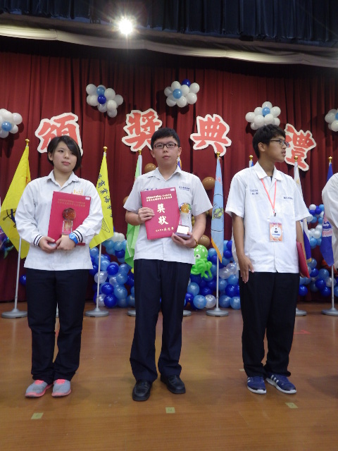 右握獎狀，左捧獎座的楊騏全同學(中)圖片